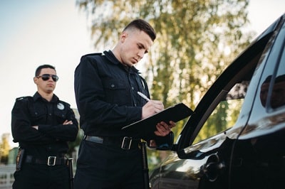 agentes-policia-masculinos-comprueban-vehiculo-carretera
