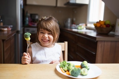 little-girl-with-eyes-closed-eating-vegetables-min